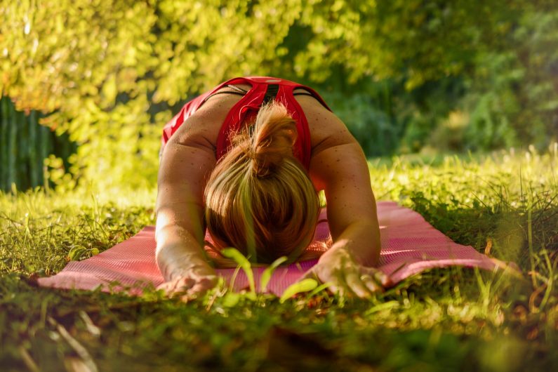 L’image représente une femme en train de pratiquer le yoga.